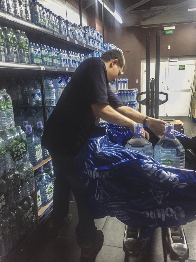Magasinier qui remet en rayon des bouteilles d'eau
