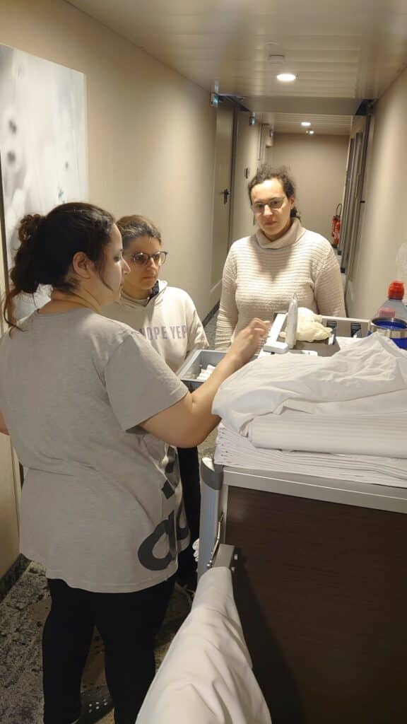 une collaboratrice de l'Hilton montrant des produits d'entretien à deux personnes accompagnées